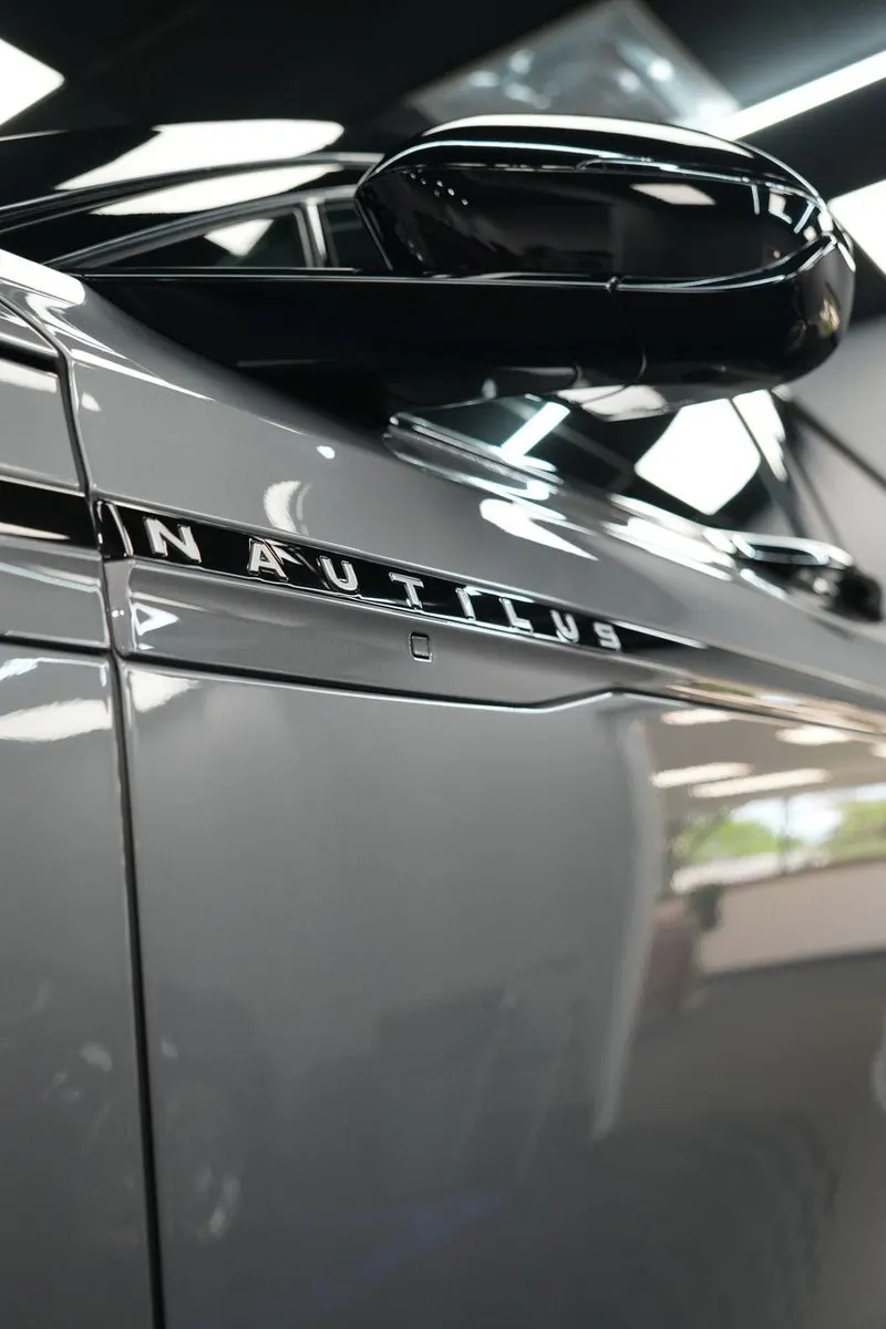 Close-up of a side mirror and 'Nautilus' badge on a vehicle's front fender.